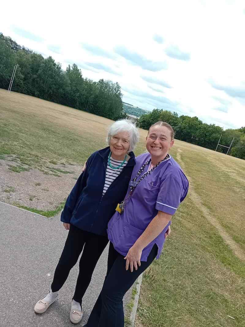 resident and one of our carers outside smiling