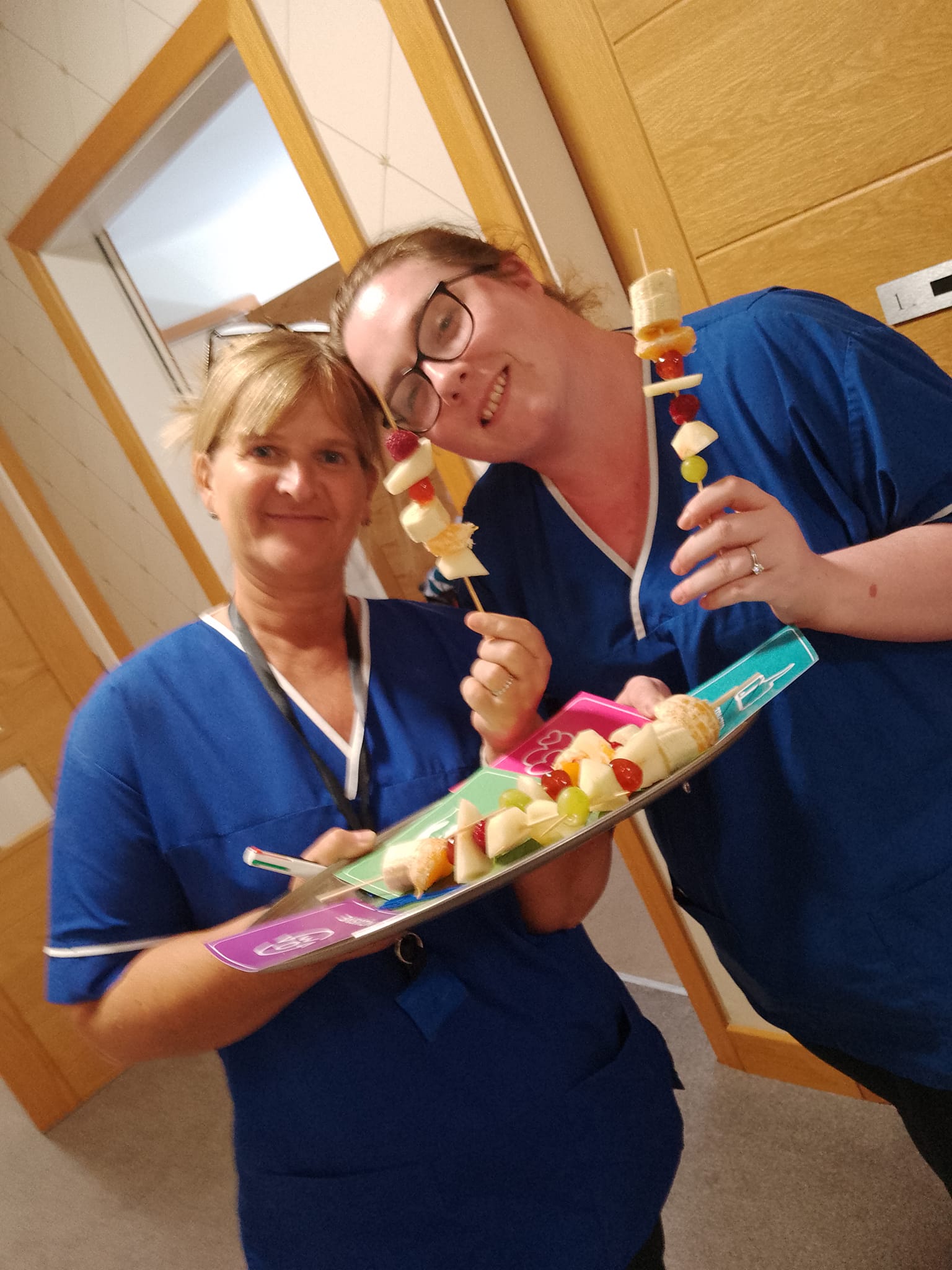 Two members of the team with fruit skewers for glad to care celebrations at The Porterbrook Care Home