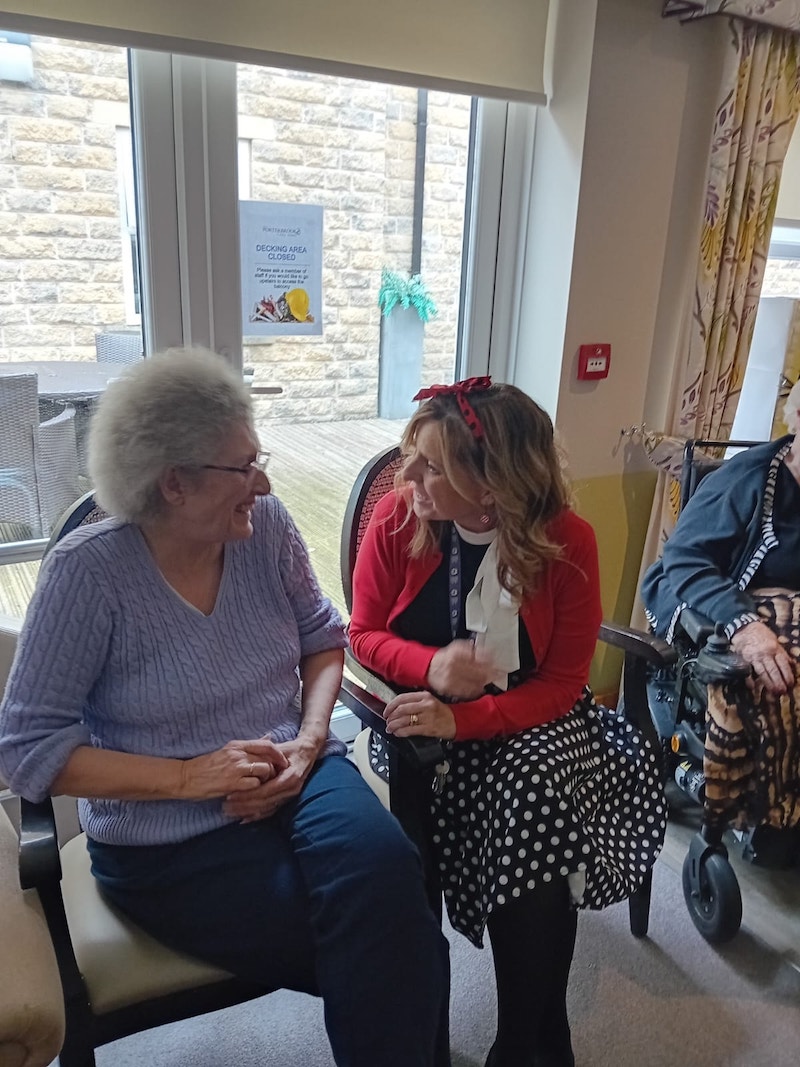 carer and resident sat together smiling