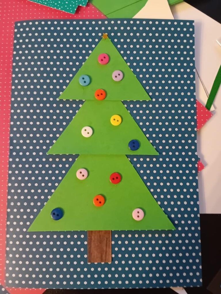 homemade christmas card with a blue background with a tree on and buttons
