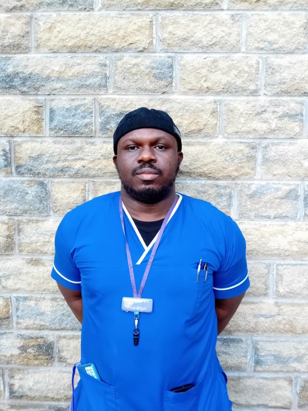 man in a nurse uniform looking at camera
