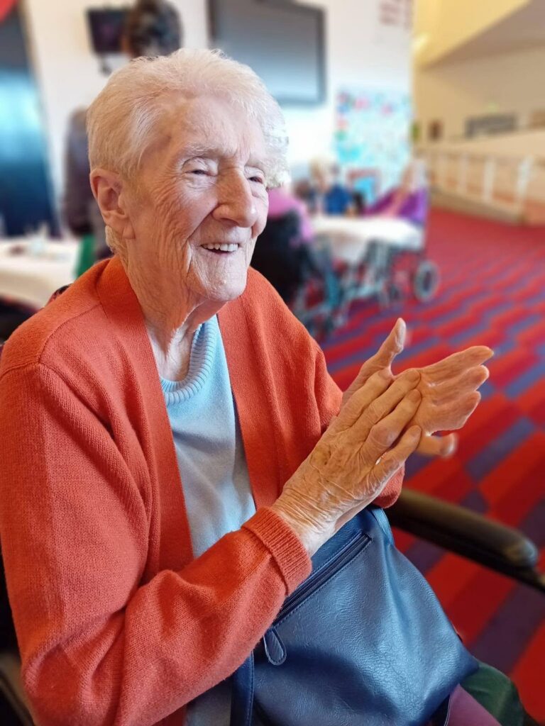older lady sat down clapping