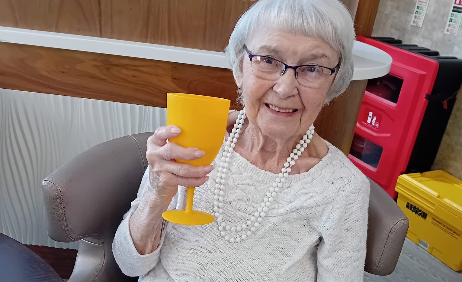 older lady holding up a yellow cup