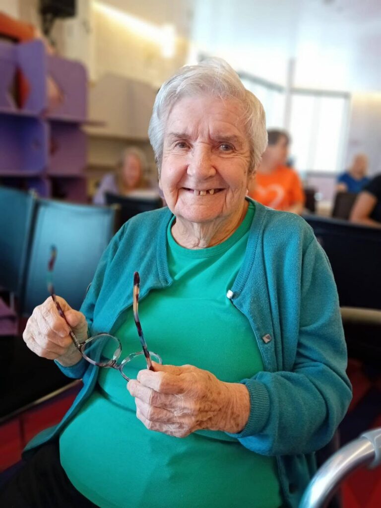 an older lady in a blue top smiling